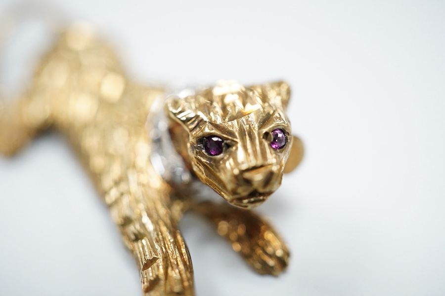 Two 9ct gold brooches, one designed as a collared leopard, its eyes set with rubies, length 5.2cm; the other designed as a hummingbird in flight, its eye set with an emerald, length 4.9cm, each in textured 9ct gold, Brit